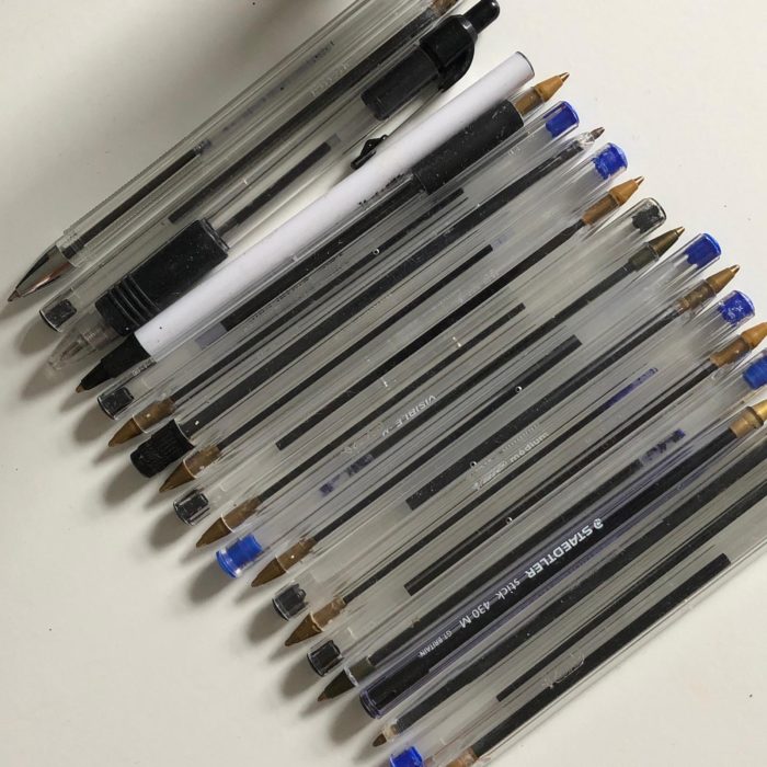 Row of black and blue biro pens