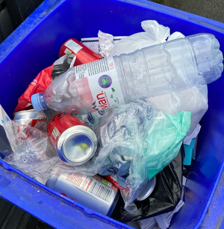 Contaminated paper and card bin. shows plastic bottles, tin cans and plastic bags