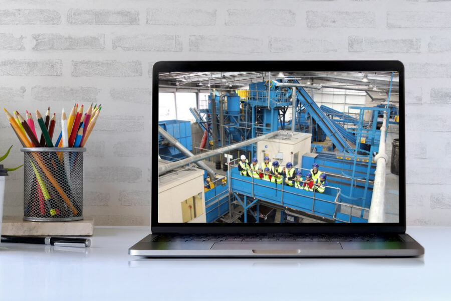 Laptop showing group of visitors on a tour of a recycling facility