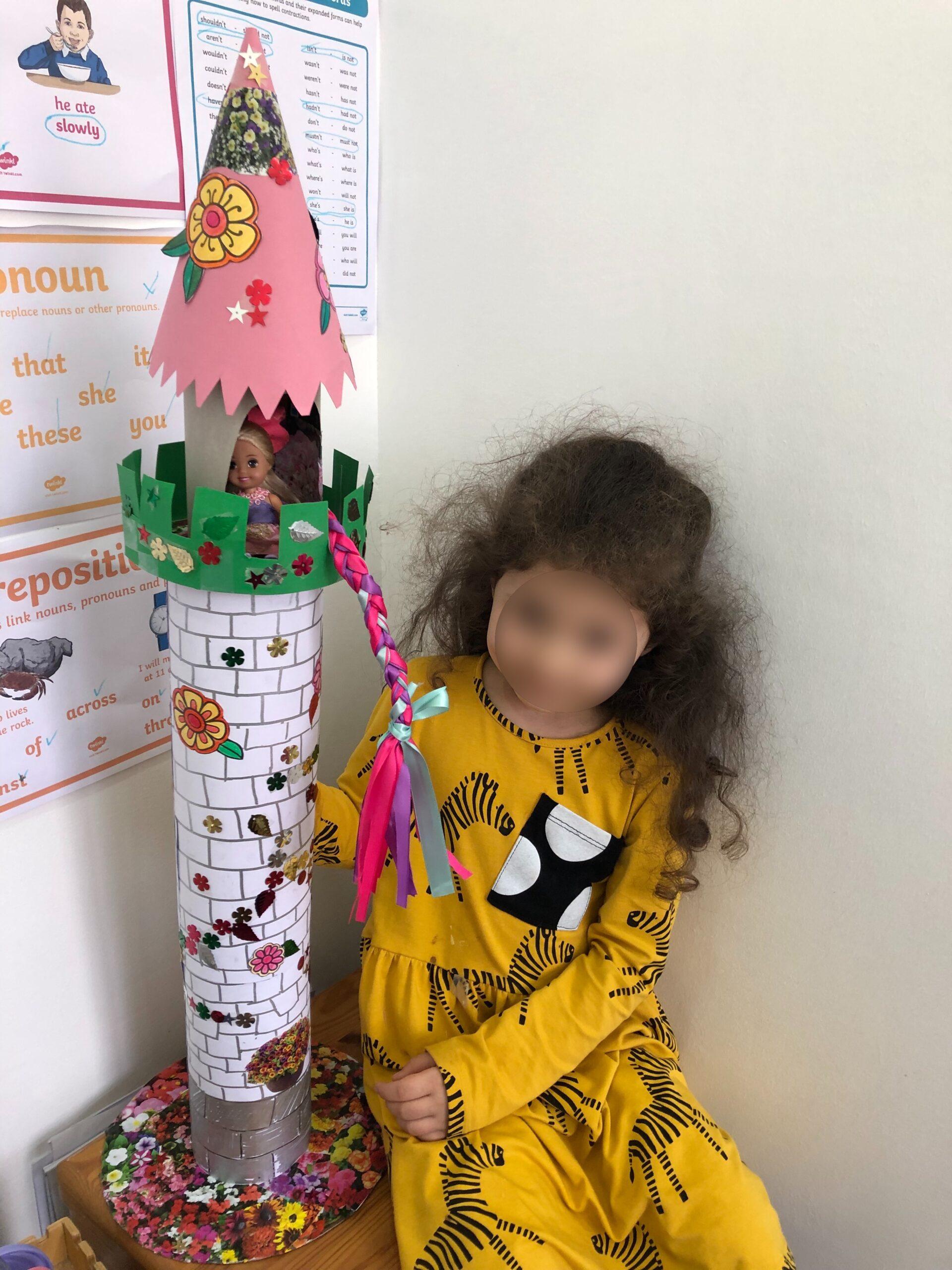Girl made a Tower from recycled carton boxes and used paper