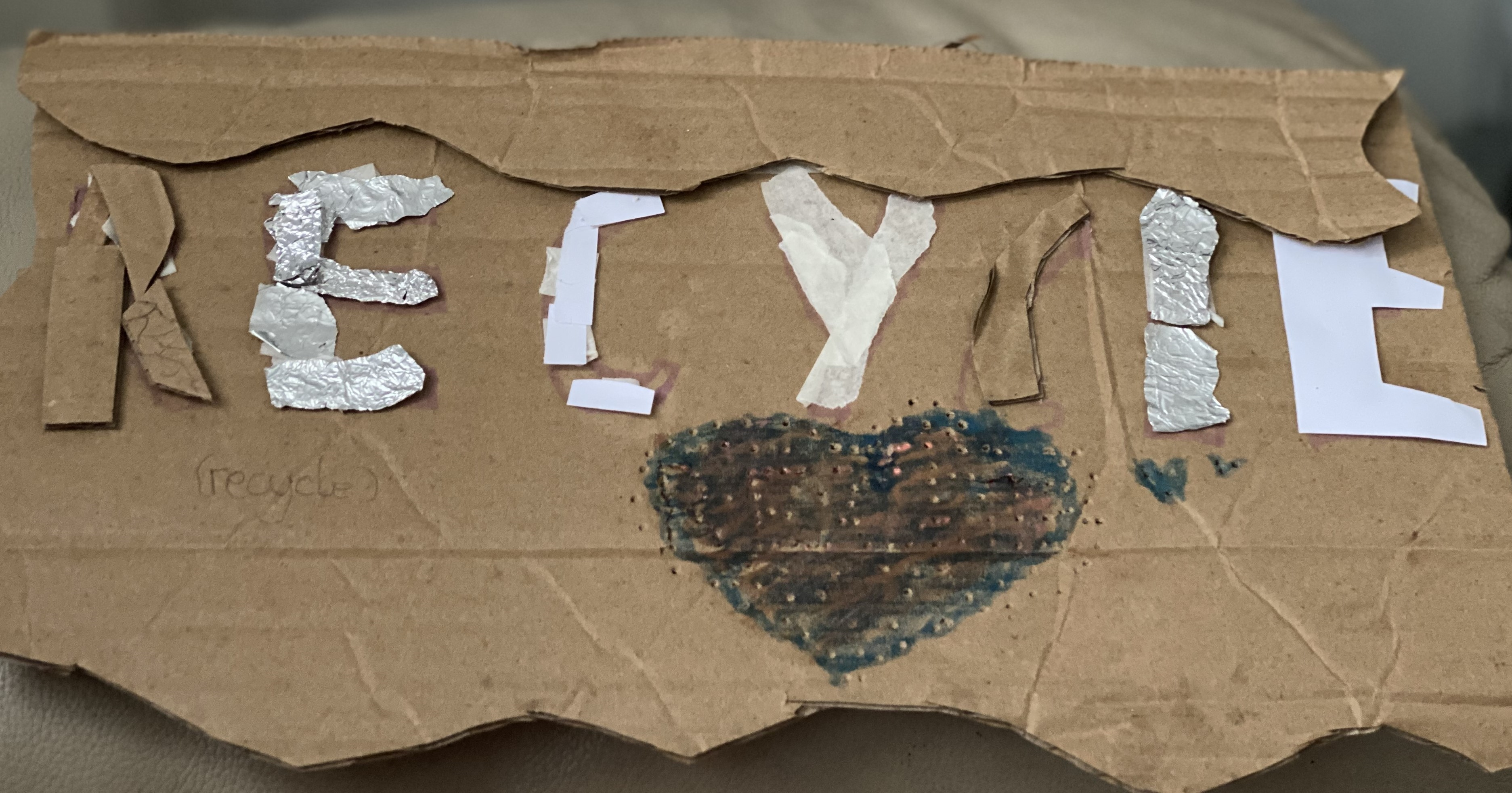 A word recycle made of tin foil and cardboard and paper