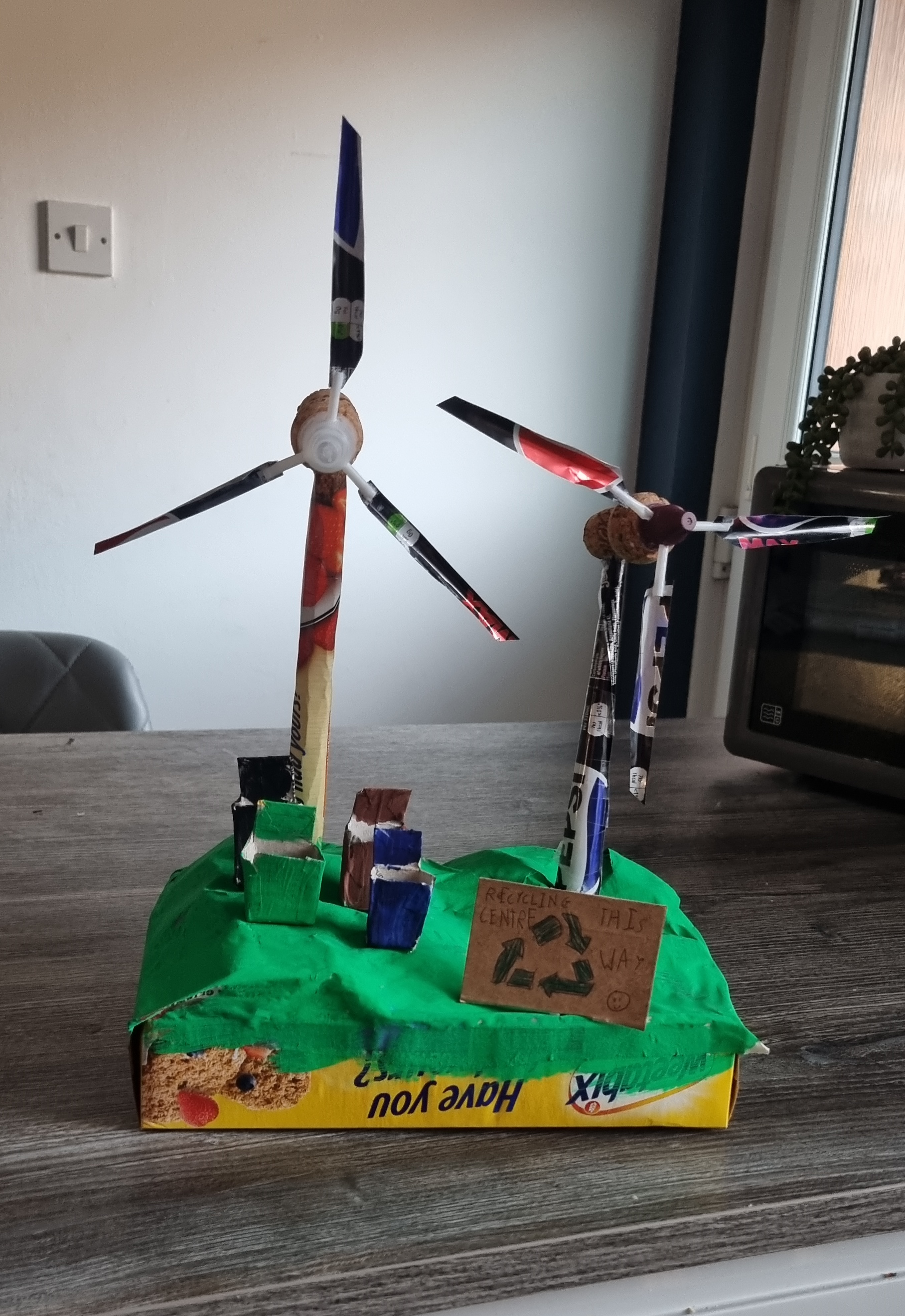 I created a wind farm out of fully recyclable materials. The hills are made out of paper, the windmills from stainless steel cans and the bins represent how we recycle in our house.