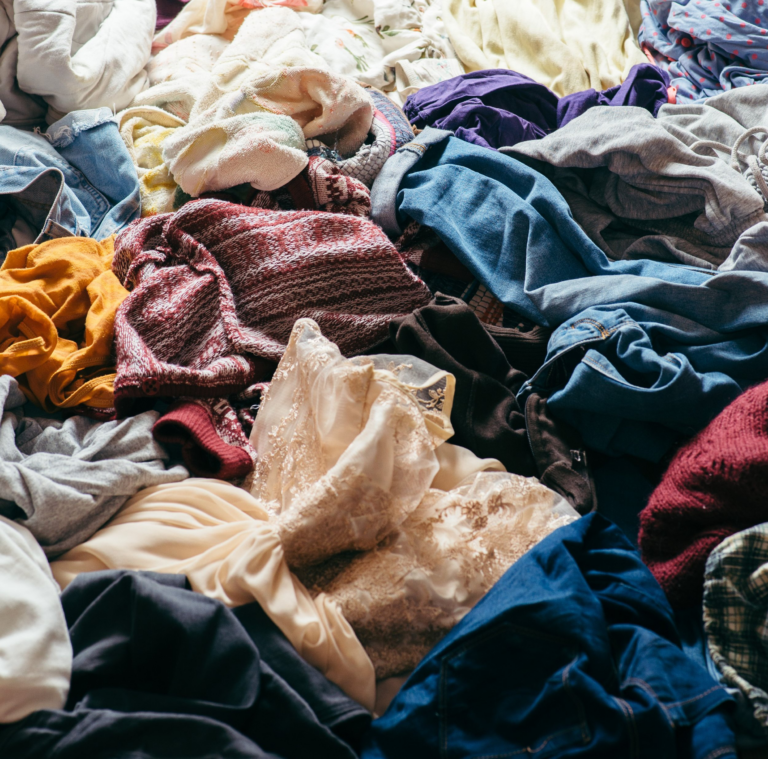 pile of used clothes on a light background. Second hand for recycling