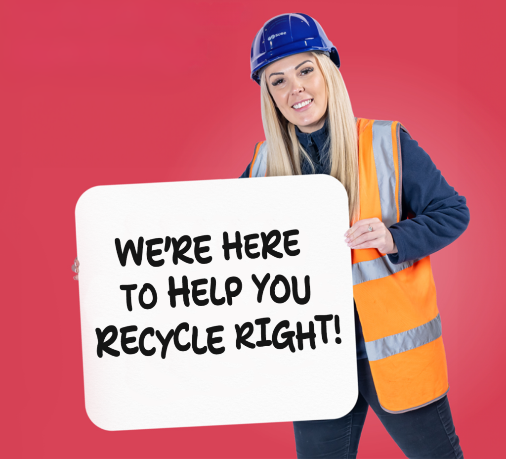 Member of staff holding a sign that says "we're here to help you recycle right"