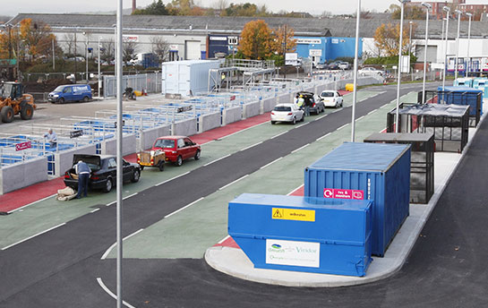 Overview of a Greater Manchester Recycling Centre. People unloading recycling from cars.